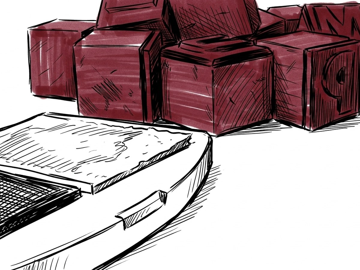 A pile of rubber stamps beside an open ink pad on a desk.